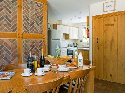 Curlew Cottage: Oak beamed dining area & kitchen beyond